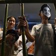 Activists standing behind makeshift bars wearing masks of Thai human rights activist Jatupat “Pai” Boonpattararaksa, who was arrested in early December 2016