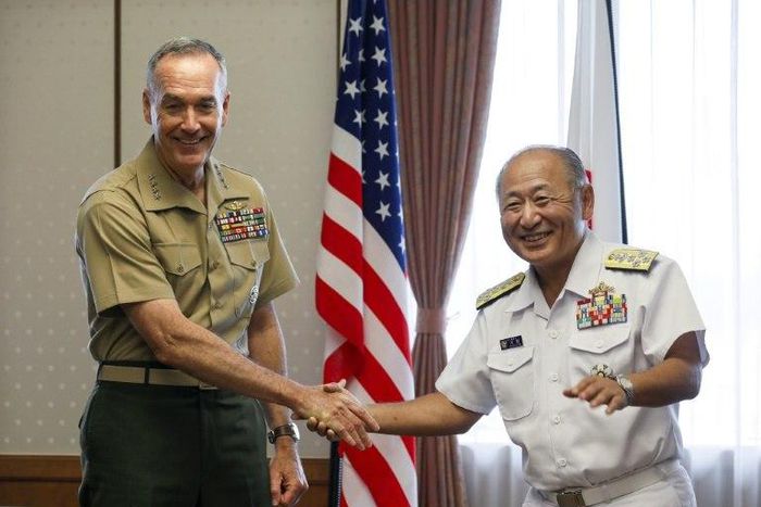 General Joseph Dunford (L), the chairman of the US Joint Chiefs of Staff, shakes hands with Japan's Chief of Staff of Joint Staff Katsutoshi Kawano (R) at the start of their talks at the Defence Ministry in Tokyo