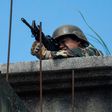 A Philippine soldier takes aim at militant positions from a rooftop in Marawi on June 13, 2017