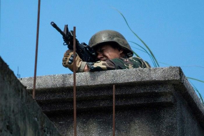 A Philippine soldier takes aim at militant positions from a rooftop in Marawi on June 13, 2017