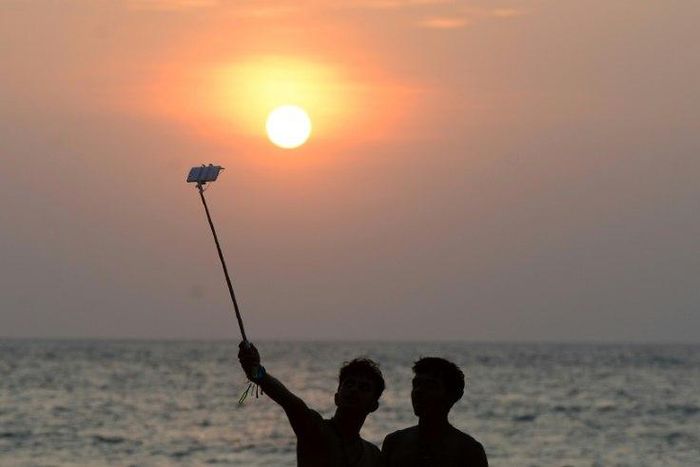 A Sri Lankan man takes a selfie on the beach in the Colombo