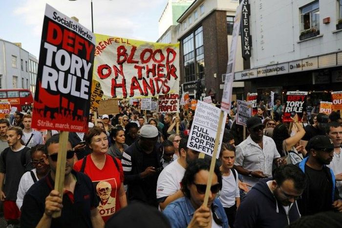 Protesters march along Notting Hill Gate after a gathering at Kensington Town Hall on June 16, as they demand justice for those affected by the fire that gutted Grenfell Tower