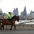 Police on horses ride past a security barrier between the road and the pavement on Waterloo Bridge in London on June 5, 2017, installed in reaction to the recent terror attacks