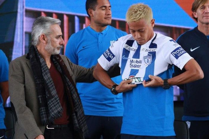 Pachuca's new footballer, Japanese Keisuke Honda, puts his new jersey on next to the team's president Jesus Martinez, during his official presentation, at the Football University on the outskirts of Pachuca, Hidalgo State, Mexico, on July 18, 2017