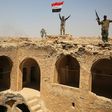 Fighters from the Hashed al-Shaabi paramilitary group raise the Iraqi flag over Tal Afar's historic Ottoman-era citadel after they and Iraqi forces seized it from Islamic State group jihadists