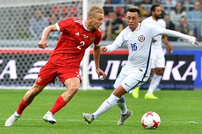 Russia's defender Igor Smolnikov (L) and Chile's forward Martin Rodriguez vie for the ball during a friendly football match in which Russia initially struggled but came back at the end of the game