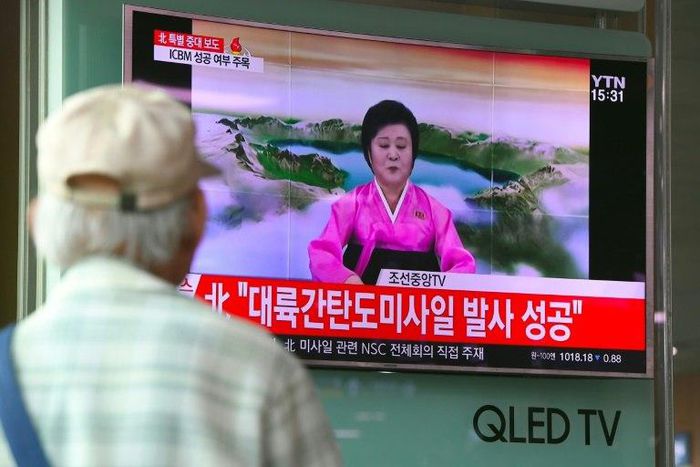People watch a television news broadcast showing a North Korean announcer reading a statement on the country's new ICBM test, at a railway station in Seoul on July 4, 2017