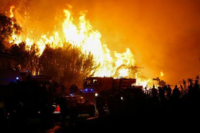 Firefighters work to put out a fire in Biguglia, on the French Mediterranean island of Corsica