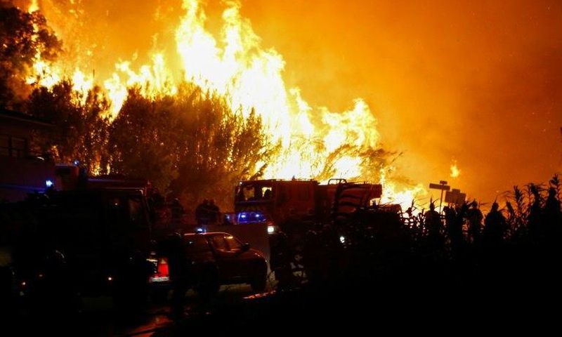 Firefighters work to put out a fire in Biguglia, on the French Mediterranean island of Corsica