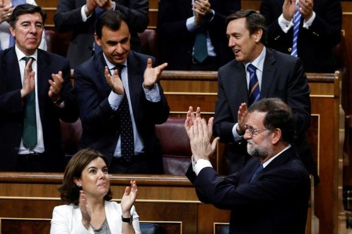 Spaain's Prime Minister Mariano Rajoy (R) is applauded by party colleagues at the Congress of Deputies in Madrid on June 14, 2017 after his party survived a vote of no confidence tabled to denounce a series of corruption scandals