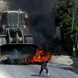A Palestinian youth runs from the path of an Israeli army bulldozer during clashes in the village of Kobar, west of Ramallah, on July 22, 2017