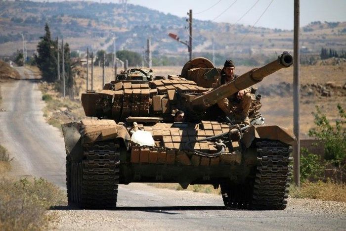 Opposition fighters drive a tank in Syria's southwestern Quneitra province in June 2017