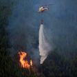 A helicopter drops water over a wildfire in Carvalho, next to Pampilhosa da Serra. The huge forest fire that erupted in central Portugal Saturday has killed at least 64 people and injured more than 100