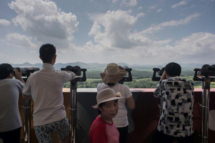 Tourists look out towards North Korea at an observation point within the Demilitarized Zone separating North and South Korea