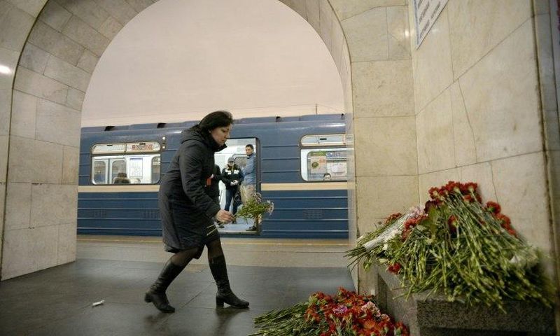 A woman places flowers in honour of the victims of the April 3 blast on the platform of Technological Institute metro station in Saint Petersburg on April 4, 2017