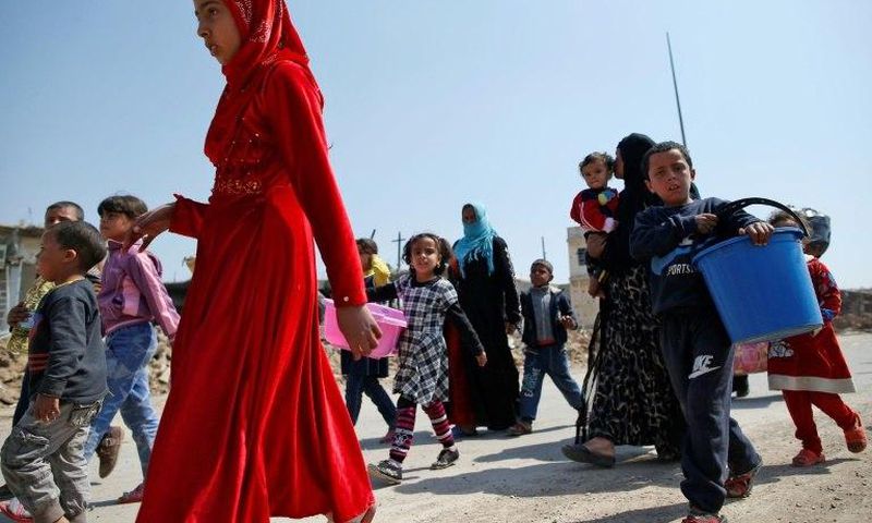 Iraqis flee on foot carrying their belongings to escape the fighting for Mosul's Old City with the Islamic State group on March 30, 2017