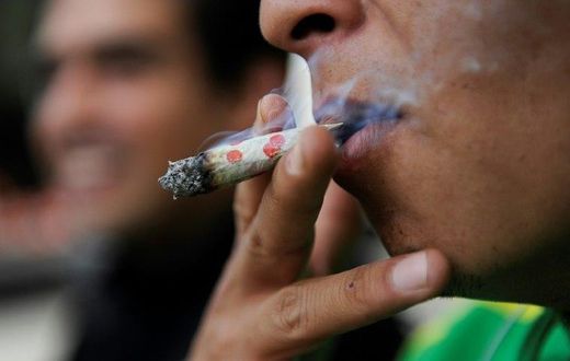 A man smokes marijuana during a demonstration in front of the Mexican Senate building in Mexico City on September 28, 2016
