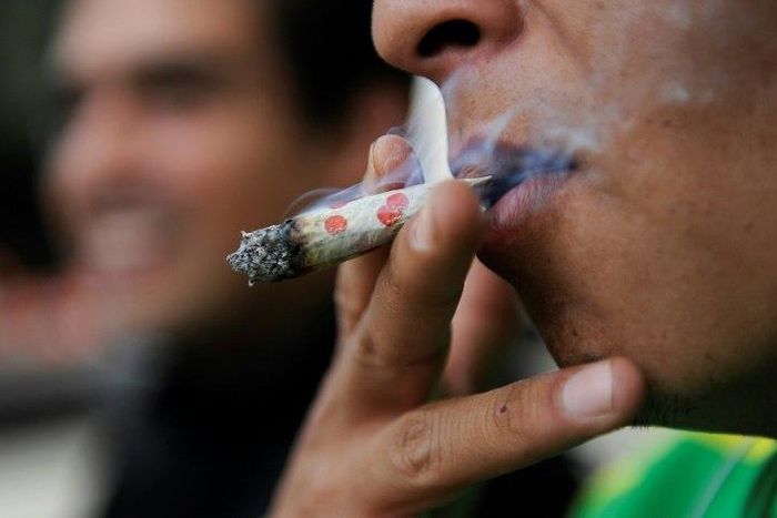 A man smokes marijuana during a demonstration in front of the Mexican Senate building in Mexico City on September 28, 2016