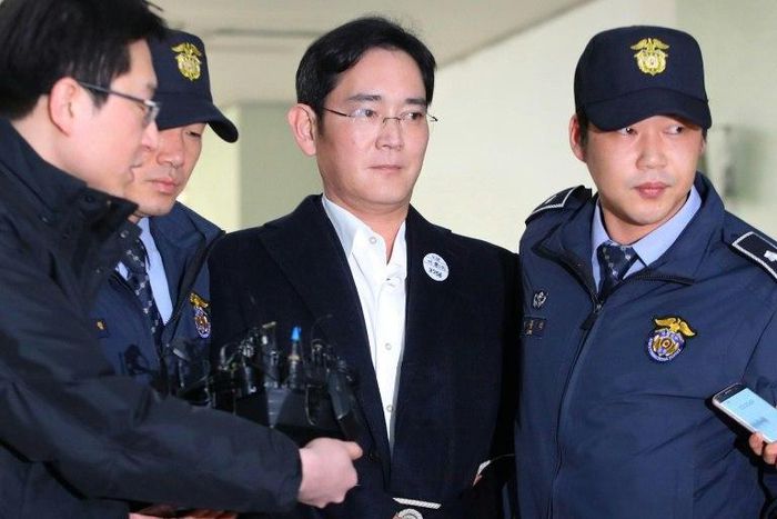 Samsung Group's heir-apparent Lee Jae-Yong (C) arrives in handcuffs for questioning at the office of a special prosecutor investigating a corruption scandal in Seoul on February 18, 2017