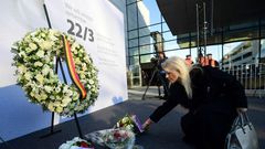A woman places a bunch of flowers during a memorial at Brussels' international airport in Zaventem