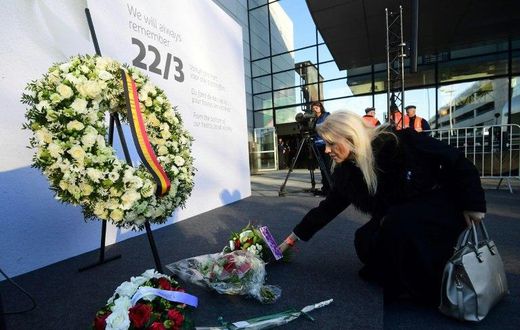 A woman places a bunch of flowers during a memorial at Brussels' international airport in Zaventem