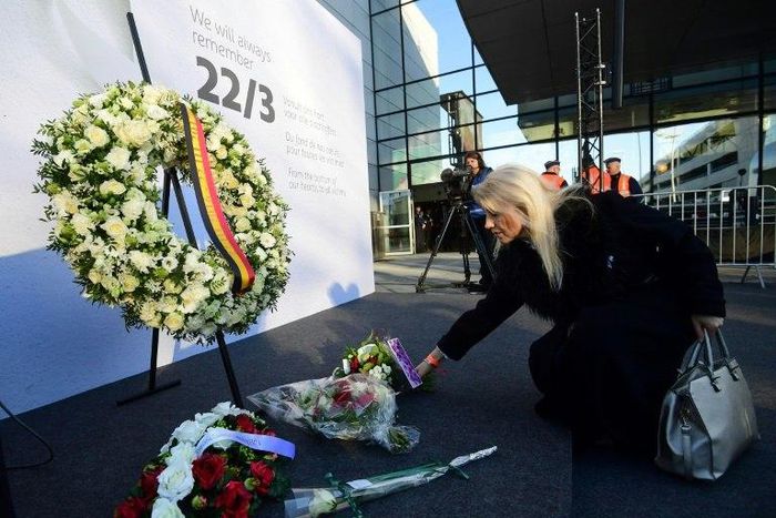 A woman places a bunch of flowers during a memorial at Brussels' international airport in Zaventem