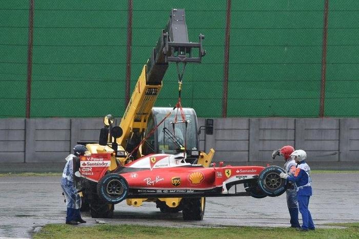 The car of Ferrari's driver Kimi Raikkonen is removed from the track after he crashed and the race was stopped during the Brazilian Grand Prix on November 13, 2016