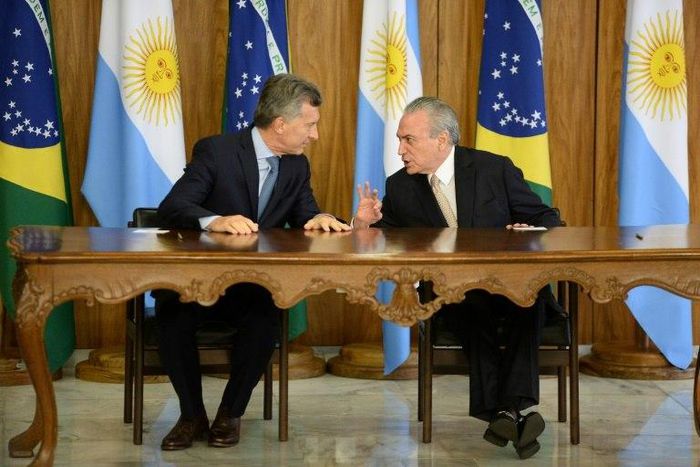 Brazilian President Michel Temer (R) and Argentina's President Mauricio Macri chat before signing bilateral agreements at the Planalto Palace in Brasilia on February 7, 2017