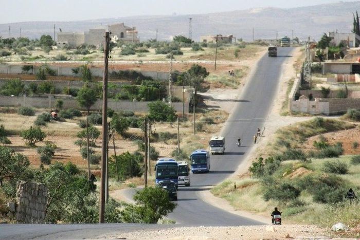 Syrian civilians and rebels, who were evacuated from the Qabun district in northeast Damascus, arrive by bus at a temporary camp in the northern countryside of Idlib province on May 15, 2017