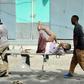 Residents carry an injured man wounded during a complex car bomb attack targeting a Mogadishu hotel on January 25, 2017