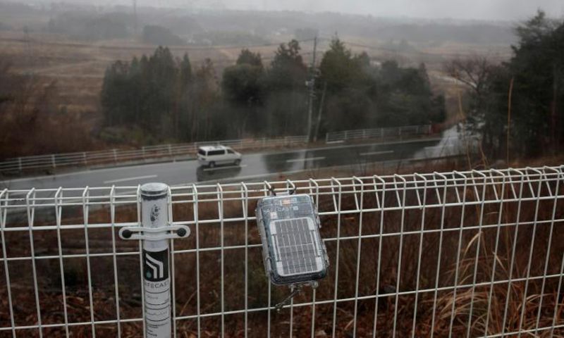 A geiger counter attached to a fence near the Daiichi power plant measures radiation in Okuma town, Fukushima prefecture