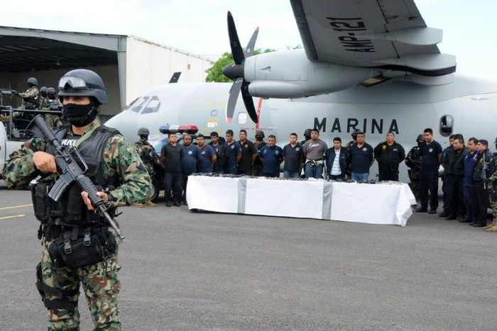 Mexican marines escort a group of alleged municipal policemen working for the Zeta cartel, five members of the same cartel and nine escaped inmates, in Veracruz, in 2011