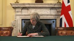 Britain's Prime Minister Theresa May signs a letter to European Council President Donald Tusk invoking Article 50 and signalling the UK's intention to leave the EU, in the cabinet office inside 10 Downing Street on March 28, 2017