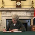 Britain's Prime Minister Theresa May signs a letter to European Council President Donald Tusk invoking Article 50 and signalling the UK's intention to leave the EU, in the cabinet office inside 10 Downing Street on March 28, 2017