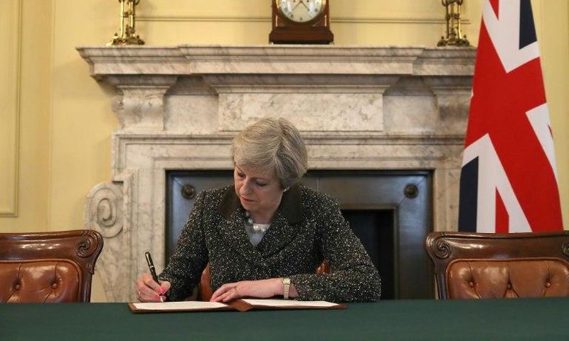 Britain's Prime Minister Theresa May signs a letter to European Council President Donald Tusk invoking Article 50 and signalling the UK's intention to leave the EU, in the cabinet office inside 10 Downing Street on March 28, 2017
