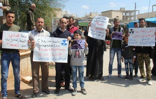 Residents of Khan Sheikhun in northern Syria hold placards and pictures on April 7, 2017 during a protest condemning a suspected chemical weapons attack on their town earlier this week that killed at least 87 people