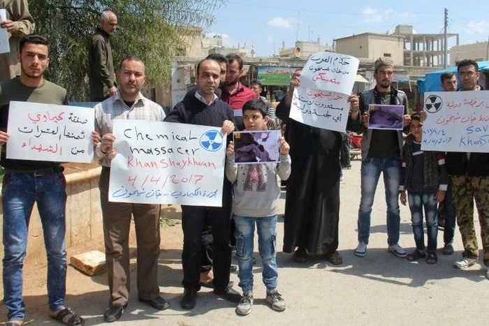 Residents of Khan Sheikhun in northern Syria hold placards and pictures on April 7, 2017 during a protest condemning a suspected chemical weapons attack on their town earlier this week that killed at least 87 people