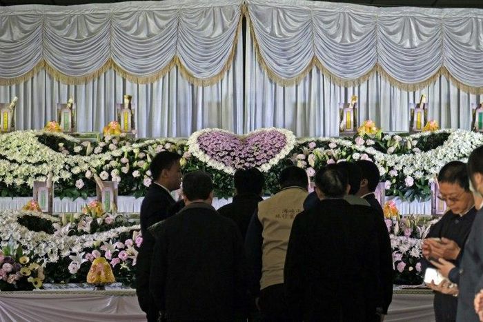 Relatives (C) mourn the victims of a bus crash in Taiwan that killed 33 local tourists