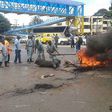 Police and county government askaris remove bonfires lit by traders protesting their eviction at Buxton in Mombasa.
