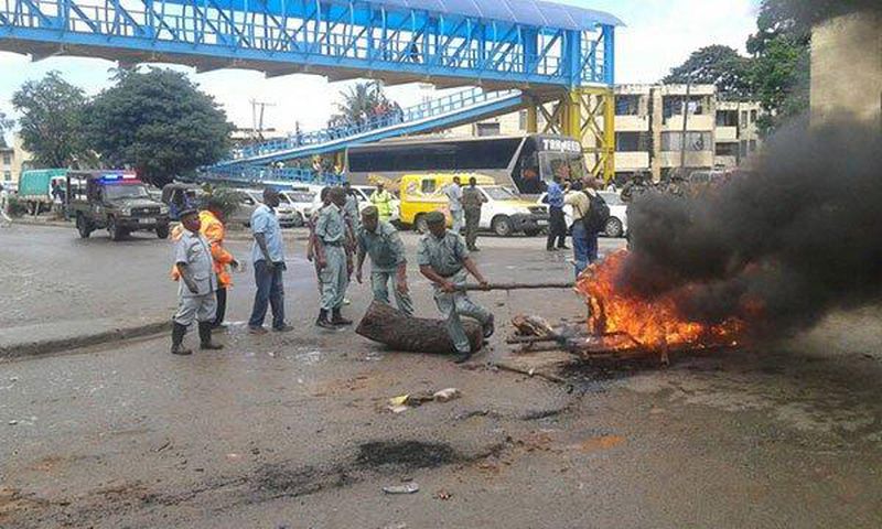 Police and county government askaris remove bonfires lit by traders protesting their eviction at Buxton in Mombasa.