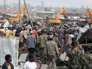 Members of the public watch as bulldozers demolish buildings in Nairobi