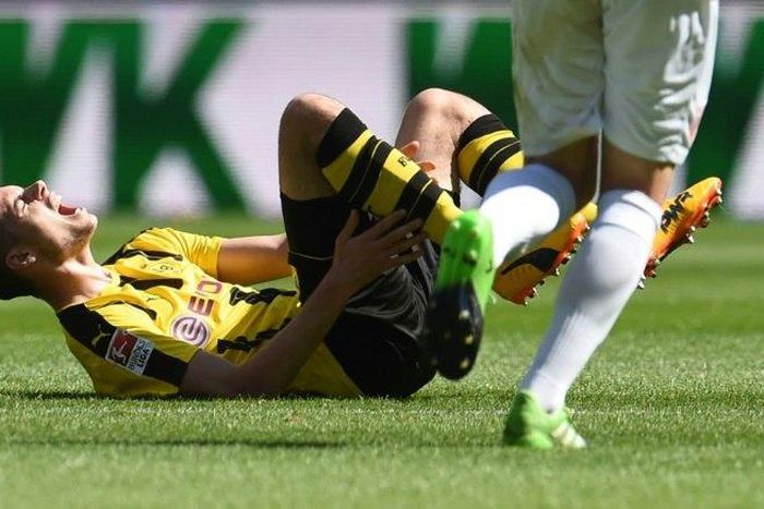 Dortmund's midfielder Julian Weigl lies injured on the pitch during the German first division Bundesliga football match against FC Augsburg on May 13, 2017