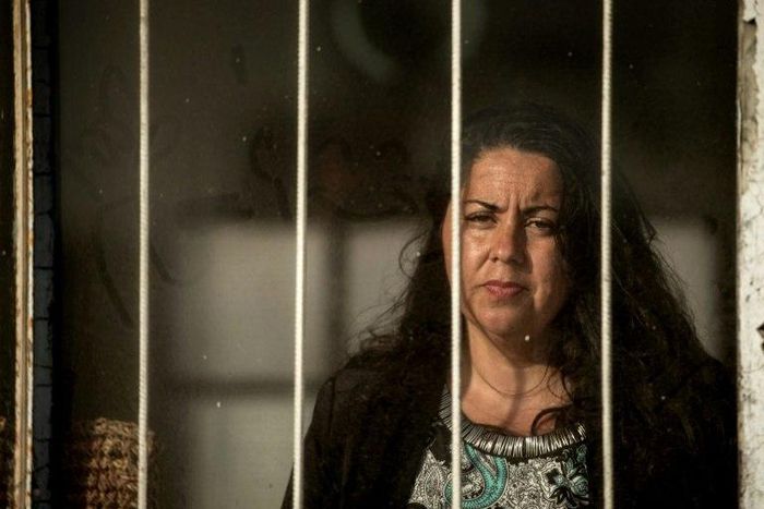 Jaqueline Jimenez looks out from the window of a building where she used to live, near Chile's port of Antofagasta