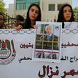 Palestinian journalists hold placards during a demonstration on April 24, 2016, outside the Red Cross offices in the West Bank city of Ramallah, in support of their colleague, Omar Nazzal, who was detained the previous day by Israeli forces