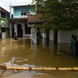 Sri Lankan residents make their way through floodwaters in Kaduwela. Emergency teams are rushing to distribute aid to half a million displaced after the island's worst flooding in more than a decade claimed 126 lives and left scores more missing