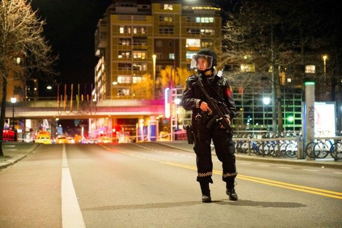 A police officer stands guard near a cordened off area in central Oslo on late April 8, 2017, following the discovery of a 'bomb-like device'