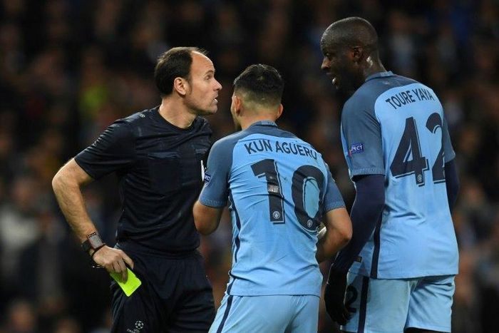 Manchester City midfielder Yaya Toure (R) and striker Sergio Aguero (C) remonstrate with the referee after Aguero was shown a yellow during the Champions League Round of 16 first-leg in Manchester, north west England on February 21, 2017