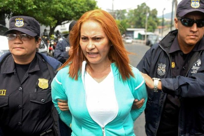 Marixa Lemus, alias "La Patrona," from Guatemala is escorted by police as she is presented to the media after her arrest for allegedly heading a criminal network involved in kidnapping and murder, in San Salvador on May 25, 2017