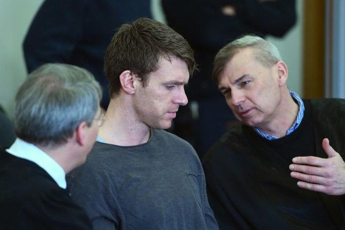 German far-right politician Maik Schneider (centre) talks to his lawyers during his trial in Potsdam, on February 9, 2017