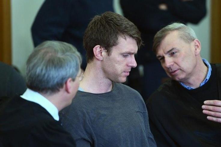German far-right politician Maik Schneider (centre) talks to his lawyers during his trial in Potsdam, on February 9, 2017